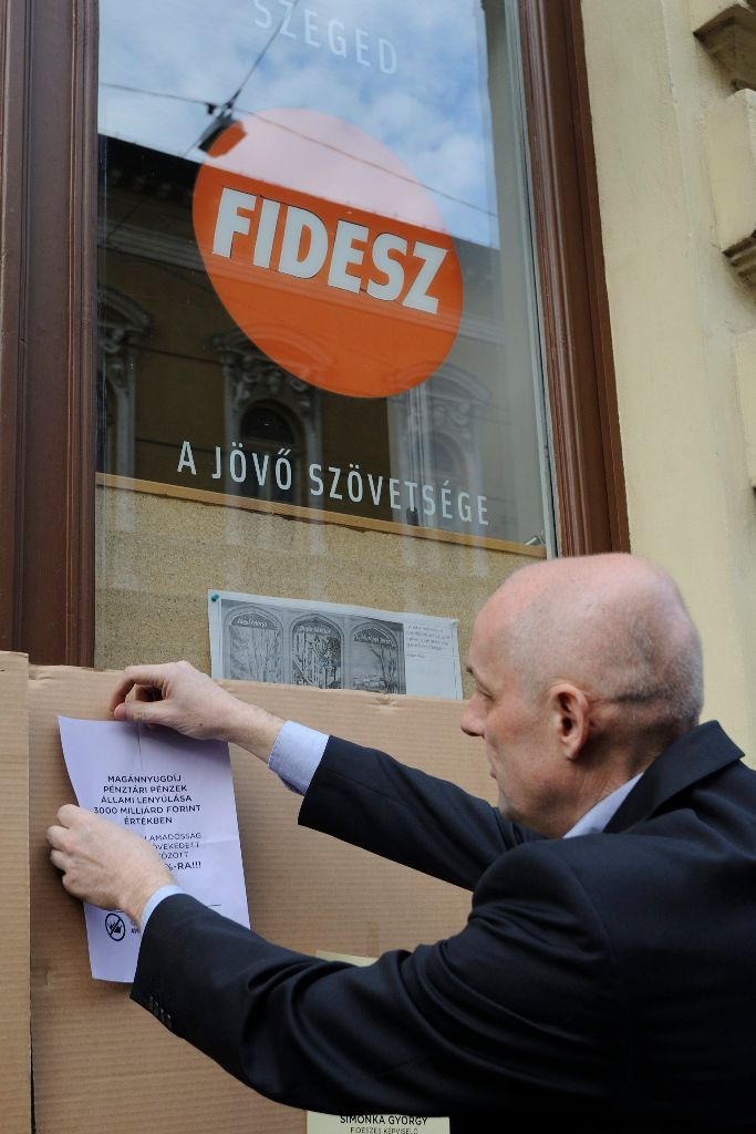 Nagy Sándor (Együtt) városfejlesztési alpolgármester kiragaszt egy korrupciós történetet elmesélõ szórólapot a szegedi Fidesz-iroda bejáratához a civilek és ellenzéki pártok A korrupció kormánya ellen címmel meghirdetett tüntetésén 2015. április 20-án. MTI Fotó: Kelemen Zoltán Gergely