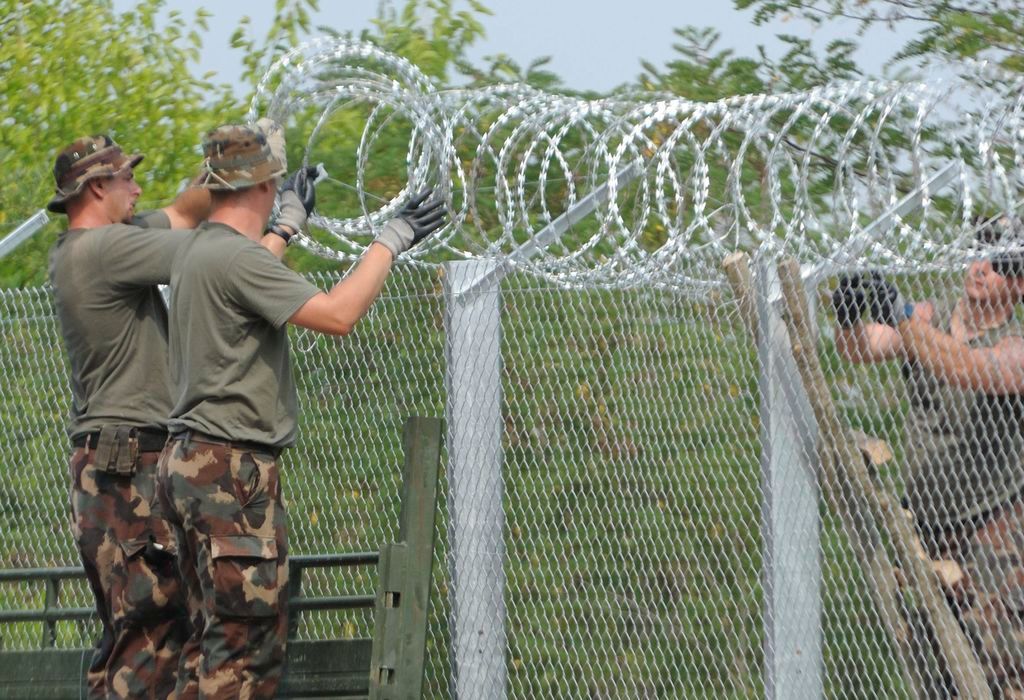 Mórahalom, 2015. július 18. Katonák NATO-drótot rögzítenek a kerítés tetejére az ideiglenes biztonsági határzár 175 méteres mórahalmi mintaszakaszán a magyar-szerb határon 2015. július 18-án. MTI Fotó: Kelemen Zoltán Gergely