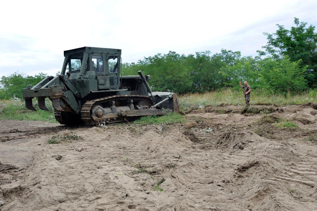 Mórahalom, 2015. július 13. Egy honvédségi lánctalpas munkagép az ideiglenes mûszaki határzár építésének elõkészítéseként földmunkákat végez a magyar-szerb határon, Mórahalom közelében 2015. július 13-án. MTI Fotó: Kelemen Zoltán Gergely