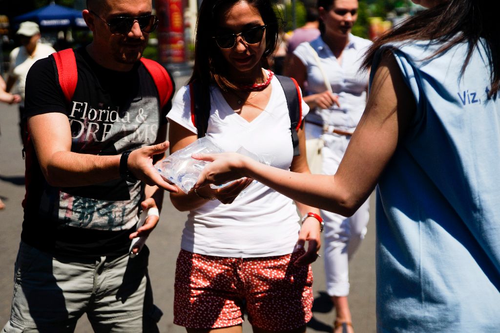 Budapest, 2015. július 5. Zacskós vizet osztanak a kánikulában a Fõvárosi Vízmûvek standjánál a budapesti Deák Ferenc téren 2015. július 5-én. Az országos tiszti fõorvos július 4-tõl, szombattól július 8-ig, szerda éjfélig a legmagasabb, harmadfokú hõségriadót rendelte el, mert ebben az idõszakban eléri vagy meghaladja a napi középhõmérséklet a 27 Celsius-fokot. MTI Fotó: Balogh Zoltán