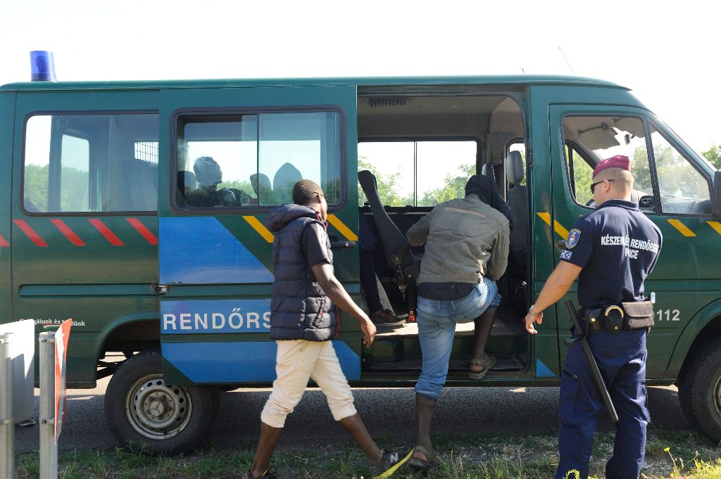 Röszke, 2015. július 11. Szenegáli határsértõk szállnak be egy rendõrautóba Röszke külterületén 2015. július 11-én. Az elõzõ napon 731 határsértõt - köztük 135 gyermeket - tartóztattak fel a rendõrök a polgárõrökkel együttmûködve Csongrád megye déli részén. MTI Fotó: Kelemen Zoltán Gergely