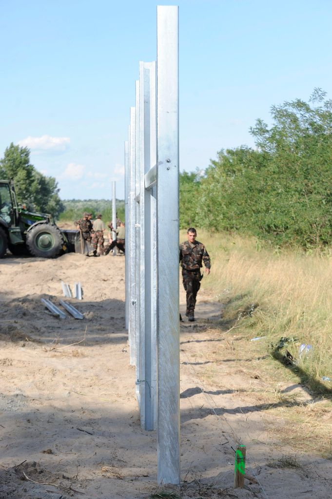 Mórahalom, 2015. július 15. Katonák kerítésoszlopokat szerelnek Mórahalom térségében a magyar-szerb határon az ideiglenes biztonsági határzár építésén 2015. július 15-én. MTI Fotó: Kelemen Zoltán Gergely