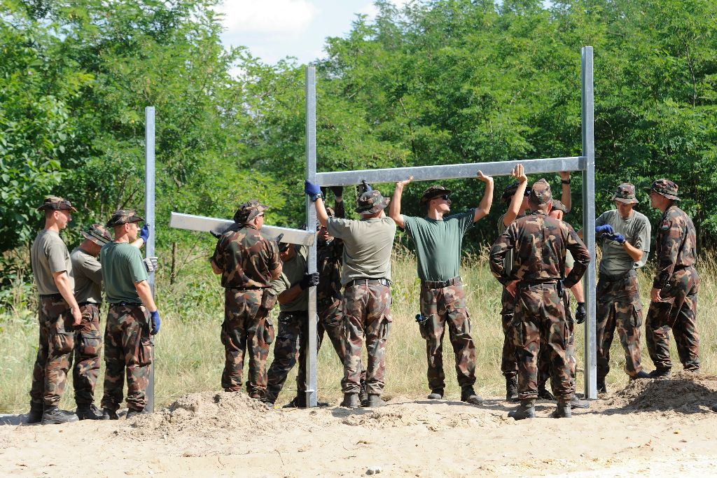 Mórahalom, 2015. július 15. Katonák kerítésoszlopokat szerelnek Mórahalom térségében a magyar-szerb határon az ideiglenes biztonsági határzár építésén 2015. július 15-én. MTI Fotó: Kelemen Zoltán Gergely