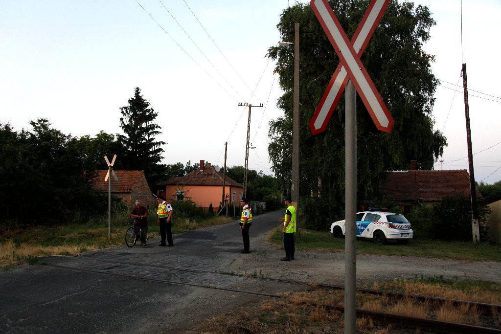 Celldömölk, 2015. július 5. Rendõrök a kilakoltatott házaknál Celldömölkön, ahol propángáz szivárog egy vasúti tartálykocsiból a rendezõ pályaudvaron 2015. július 5-én. A tûzoltók áramtalanították a szerelvényt és vízsugarakkal hûtik a tartályt, a közeli szolgálati lakásokból húsz embernek kellett elhagynia otthonát. MTI Fotó: Varga György