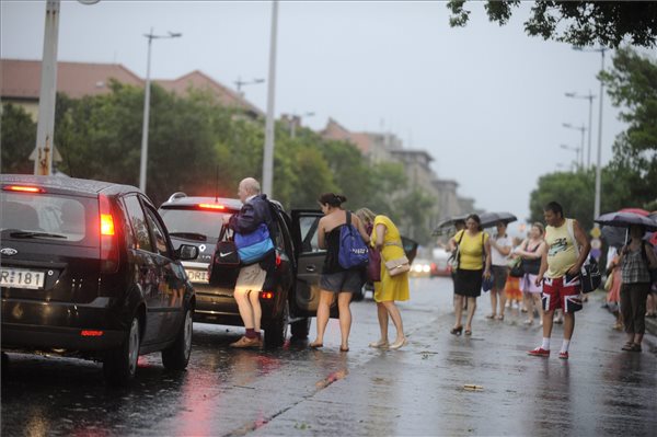 Budapest, 2015. július 8. A felhőszakadás miatt a Deák Ferenc tér és Kőbánya-Kispest között nem közlekedő 3-as metró Ecseri úti állomásánál utasok várják, hogy autósok felvegyék őket 2015. július 8-án. MTI Fotó: Mihádák Zoltán