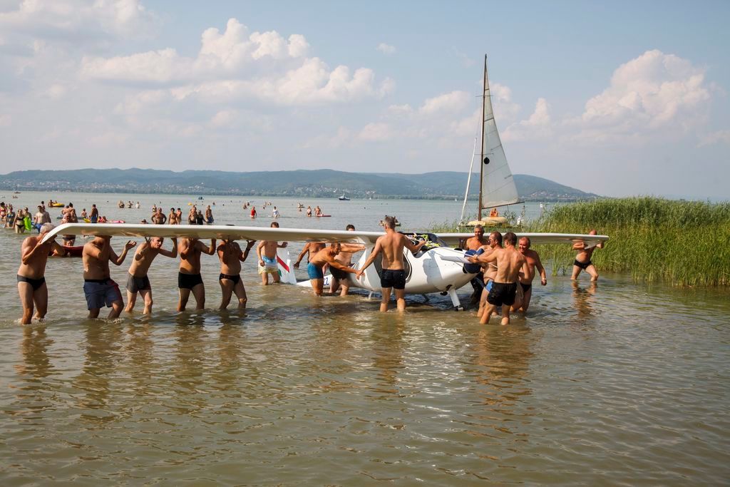 Balatonberény, 2015. július 25. Fürdõzõk partra visznek egy Balatonba zuhant vitorlázó repülõgépet Balatonberénynél 2015. július 25-én. A gép utasai nem sérültek meg. MTI Fotó: Varga György
