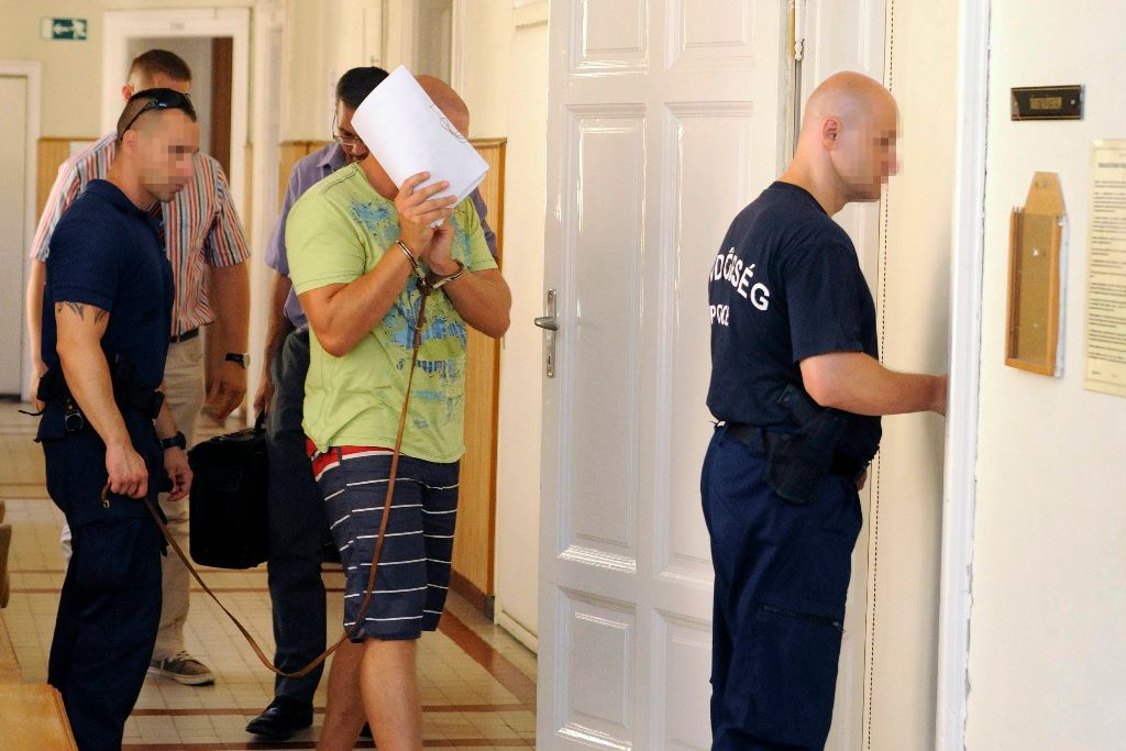 Szeged, 2015. július 23. Rendõrök vezetik a tárgyalóterembe a Szegedi Törvényszék folyosóján a Szegedi Fegyház és Börtön egy korábbi munkatársát (k), aki a gyanú szerint 2015. július 18-án a városban bántalmazott egy bevándorlónak nézett férfit, barátnõjét és a fiatal lány testvérét 2015. július 23-án. A bíróság 30 napra elrendelte a csoportosan elkövetett közösség tagja elleni erõszak és súlyos testi sértés bûntettével gyanúsított férfi elõzetes letartóztatását. MTI Fotó: Kelemen Zoltán Gergely