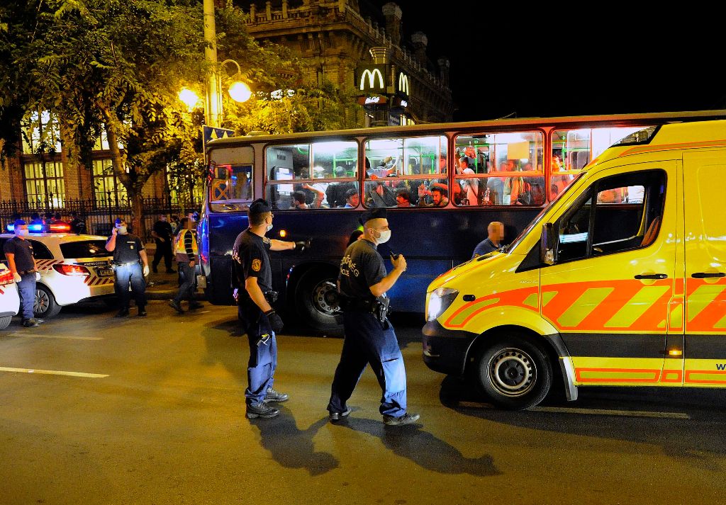 Budapest, 2015. július 29. Rendõrök menedékkérõket szállító autóbusz mellett Budapesten, a Nyugati pályaudvarnál, ahonnan ötvenhat felnõttet és gyereket vittek kórházba ismeretlen fertõzés miatt 2015. július 28-án késõ este. A hasmenésre panaszkodó betegeket és a velük érintkezõket is az Egyesített Szent László és Szent István Kórházba vitték kivizsgálásra. MTI Fotó: Mihádák Zoltán