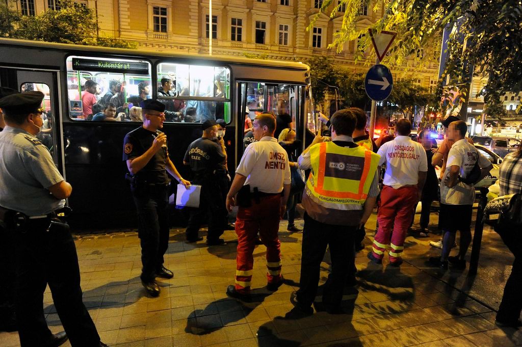 Budapest, 2015. július 29. Rendõrök és mentõk menedékkérõket szállító autóbusz mellett Budapesten, a Nyugati pályaudvarnál, ahonnan ötvenhat felnõttet és gyereket vittek kórházba ismeretlen fertõzés miatt 2015. július 28-án késõ este. A hasmenésre panaszkodó betegeket és a velük érintkezõket is az Egyesített Szent László és Szent István Kórházba vitték kivizsgálásra. MTI Fotó: Mihádák Zoltán