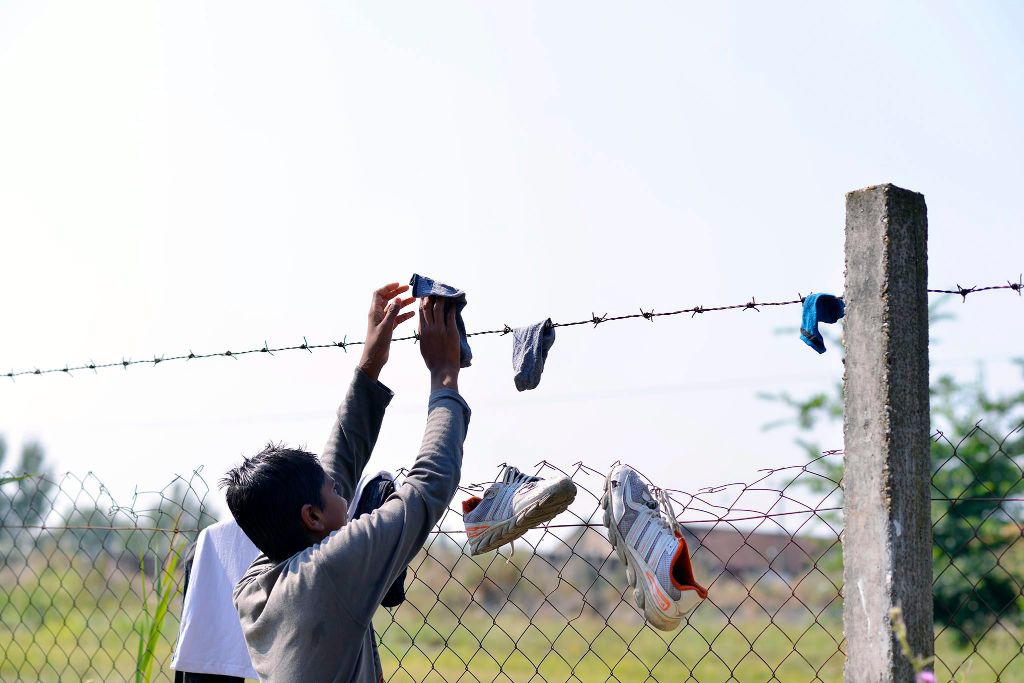 Szabadka, 2015. augusztus 14. Egy afgán férfi szárítja ruháit a vajdasági Szabadkán, egy régi, elhagyatott téglagyárnál 2015. augusztus 14-én. Az illegális bevándorlók itt várakoznak, mielõtt átlépik a szerb-magyar határt. MTI Fotó: Molnár Edvárd