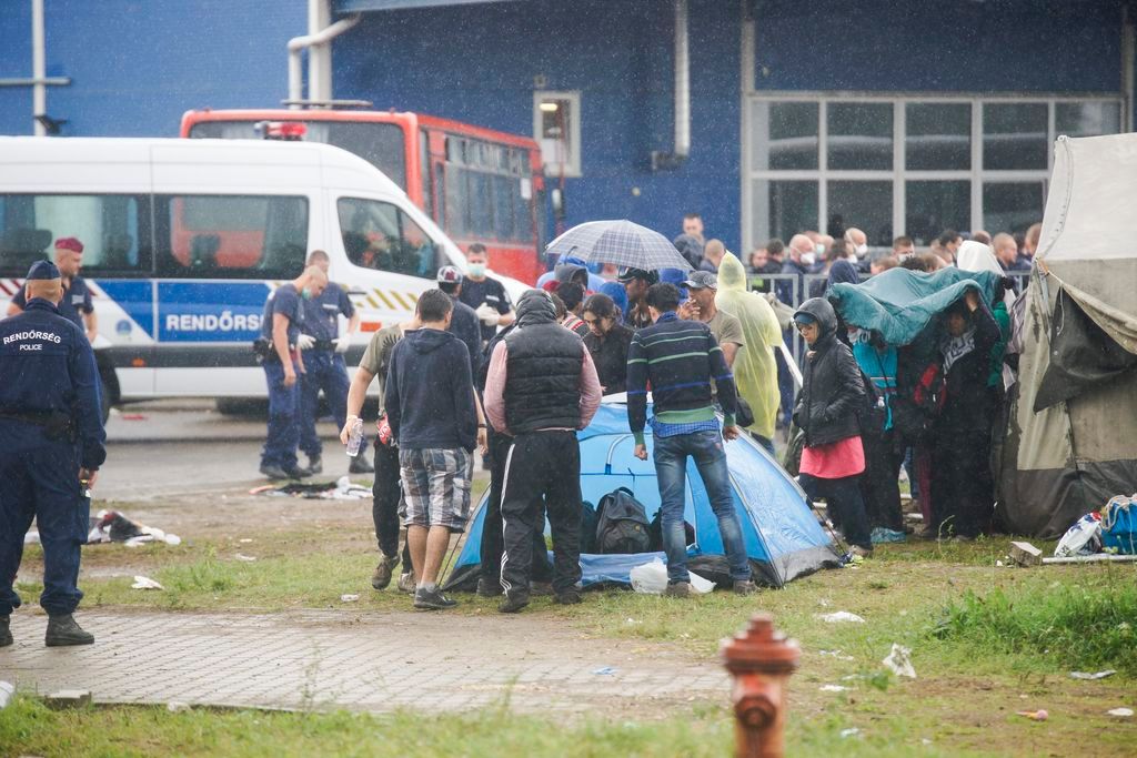 Röszke, 2015. augusztus 26. Rendõrök a zöldhatáron elfogott menekültek számára kialakított hangárnál Röszkén 2015. augusztus 26-án. Dulakodás alakult ki a táboron belül ezen a napon délelõtt, a rendõrség könnygázt is bevetett a rend helyreállítása érdekében a menekültekkel szemben. MTI Fotó: Balogh Zoltán
