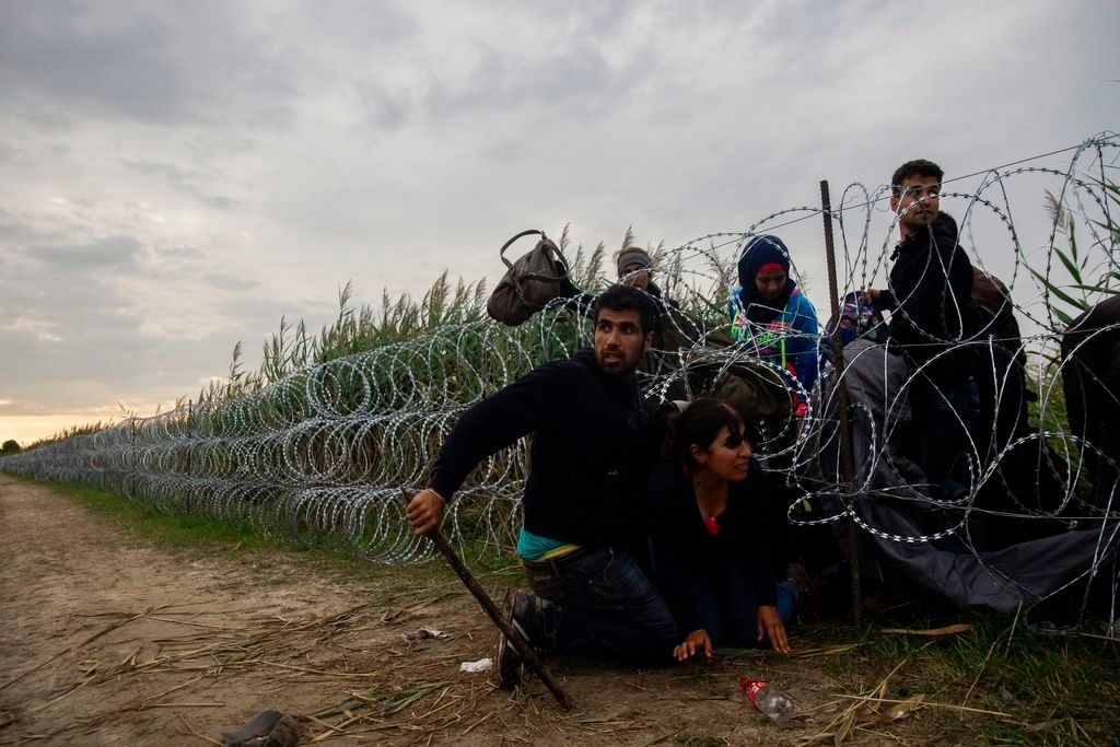 Röszke, 2015. augusztus 26. Migránsok másznak át a gyorstelepítésû drótakadályon a Röszke melletti vasúti átjáró közelében a magyar-szerb határon 2015. augusztus 26-án. MTI Fotó: Balogh Zoltán