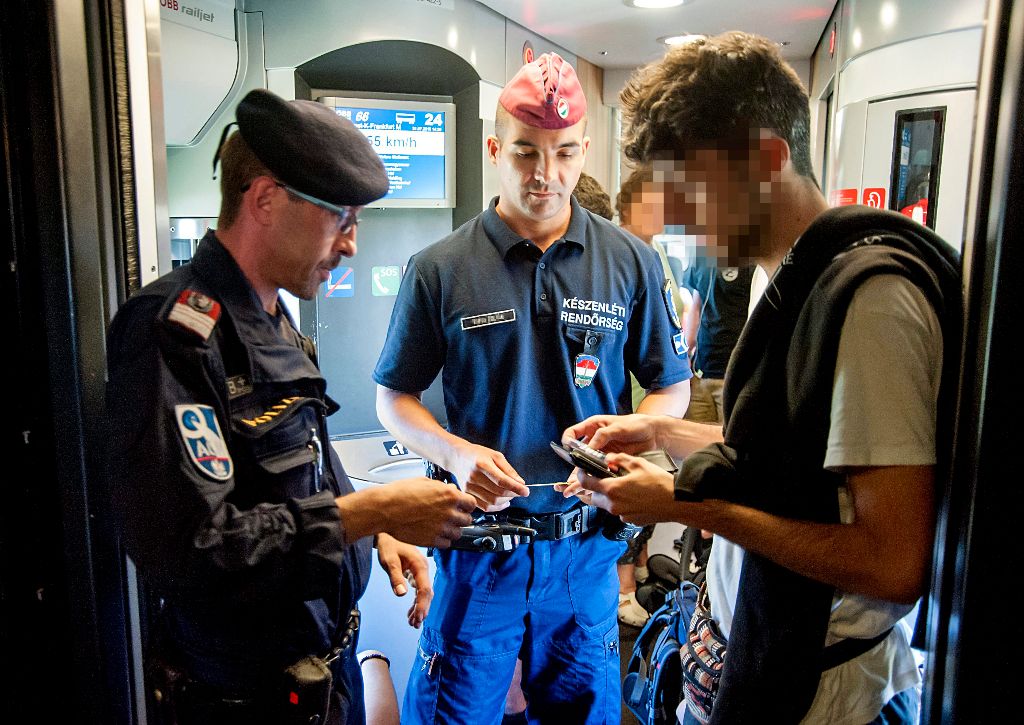 Gyõr, 2015. július 31. Osztrák és magyar rendõr igazoltat egy utast a Budapestrõl Frankfurtba tartó vonaton a gyõri vasúti pályaudvaron 2015. július 31-én. Osztrák és magyar rendõrök illegális bevándorlókat keresve közösen ellenõrzik a Magyarországról Ausztriába tartó vonatokat. MTI Fotó: Krizsán Csaba