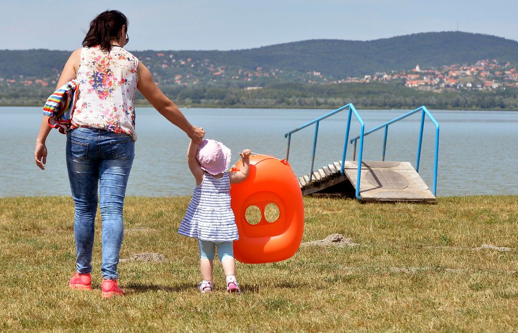 Gárdony, 2015. augusztus 1. Egy kislány édesanyjával a Velencei-tóból kiemelt lépcsõnél, Gárdonyban 2015. augusztus 1-jén. A szakhatóságok megállapították, hogy a tó partján három úgynevezett szabadstrand, vagyis természetes fürdõhely  köztük ez a partszakasz - nem rendelkezik engedéllyel. A Fejér Megyei Kormányhivatal e három fürdõhely mûködtetését felfüggesztette. A tó partján tíz kijelölt, engedéllyel rendelkezõ fürdõhely mûködik. MTI Fotó: Máthé Zoltán