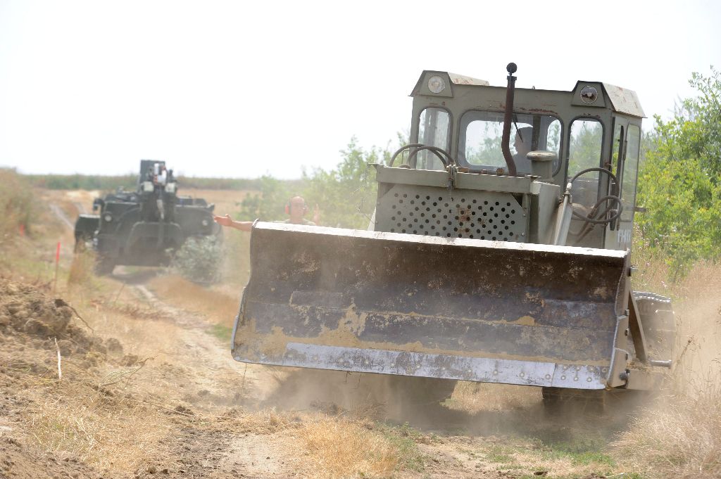 Tiszasziget, 2015. augusztus 3. A Magyar Honvédség BAT-2 típusú lánctalpas buldózere (b) és lánctalpas földmunkagépe elõkészíti a terepet az ideiglenes biztonsági határzár építéséhez a magyar-szerb határnál Tiszasziget közelében 2015. augusztus 3-án. MTI Fotó: Kelemen Zoltán Gergely