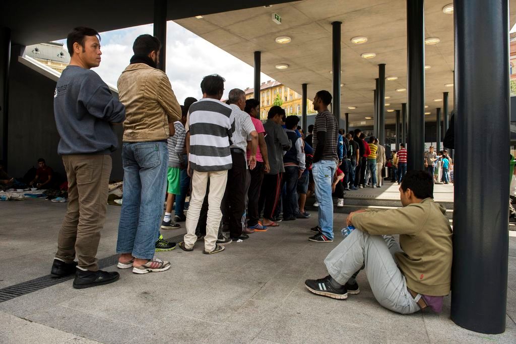 Budapest, 2015. augusztus 21. Illegális bevándorlók ételosztásnál állnak sorba a budapesti Keleti pályaudvar elõtt 2015. augusztus 21-én. Az elmúlt napokban a korábbinál több migráns gyûlt össze a pályaudvar környékén. MTI Fotó: Koszticsák Szilárd