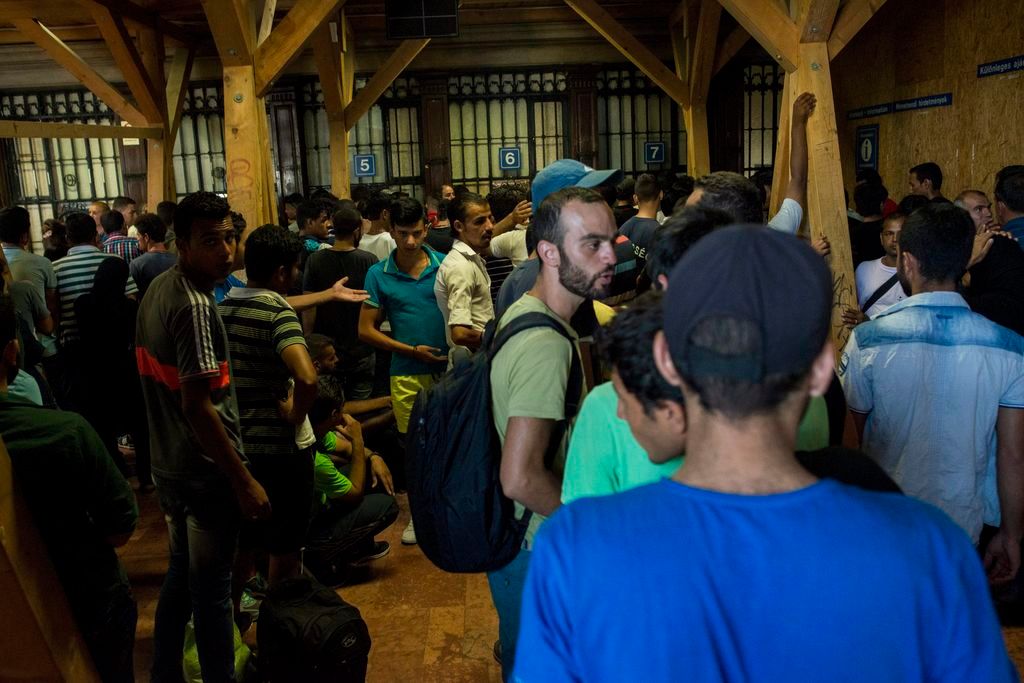 Budapest, 2015. augusztus 31. Migránsok próbálnak jegyet vásárolni egy Münchenbe tartó vonatra a budapesti Keleti pályaudvaron 2015. augusztus 31-én. Felengedik a nemzetközi járatokra a Keleti pályaudvaron azokat a migránsokat, akik érvényes okmányokkal és jeggyel rendelkeznek. MTI Fotó: Kallos Bea