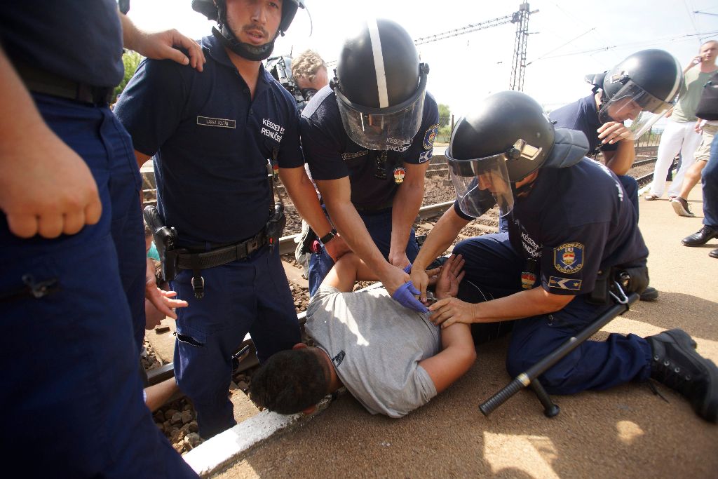 Bicske, 2015. szeptember 3. Rendõrök lefognak egy férfit a bicskei vasútállomáson, ahol leszállították az illegális bevándorlókat a Budapestrõl Sopronba tartó vonatról 2015. szeptember 3-án. MTI Fotó: Balogh Zoltán