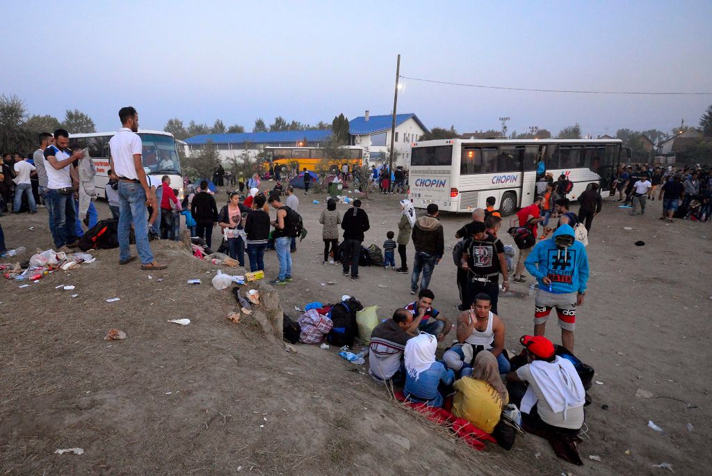 Magyarkanizsa, 2015. szeptember 14. Illegális bevándorlók buszra várnak a szerbiai Magyarkanizsa vásárterén létrehozott ideiglenes pihenõhely elõtt 2015. szeptember 13-án. Több ezer migráns fordul meg itt naponta, többsége nem is megy be a pihenõhelyre, hanem busszal, taxival vagy gyalog indul tovább Magyarország felé. MTI Fotó: Molnár Edvárd