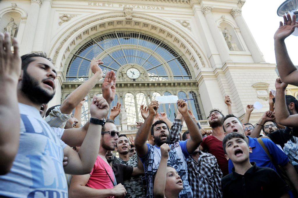 Budapest, 2015. szeptember 1. Illegális bevándorlók demonstrálnak Budapesten, a Keleti pályaudvar elõtt 2015. szeptember 1-jén, miután a rendõrség nem engedte felszállni õket a Németországba induló vonatra és kiürítette a pályaudvart. MTI Fotó: Kovács Tamás