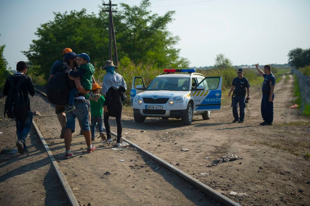 Röszke, 2015. szeptember 2. Magyar rendõrök útbaigazítást adnak a Horgos felõl érkezõ migránsoknak a Röszke melletti vasúti átjárónál, a magyar-szerb határon 2015. szeptember 2-án. MTI Fotó: Cseke Csilla