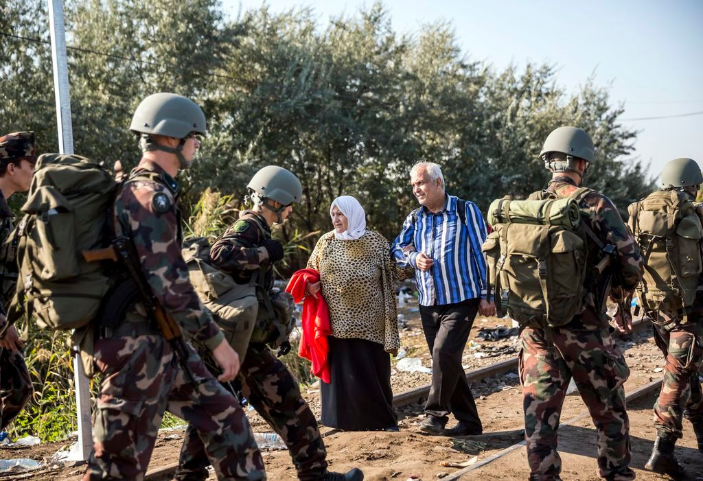 Röszke, 2015. szeptember 14. Katonák és illegális bevándorlók a magyar-szerb határon, az ideiglenes biztonsági határzár mellett, a Horgos-Szeged vasútvonal közelében, Röszke térségében 2015. szeptember 14-én. MTI Fotó: Mohai Balázs