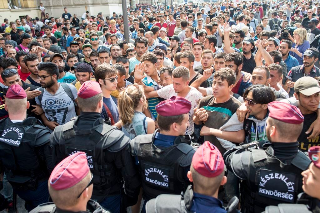Budapest, 2015. szeptember 2. Illegális bevándorlók demonstrálnak a budapesti Keleti pályaudvar elõtt, középen egy magyar önkéntes nyugtatja õket 2015. szeptember 2-án. A rendõrség nem engedi felszállni a migránsokat a Németországba induló vonatra. MTI Fotó: Kallos Bea