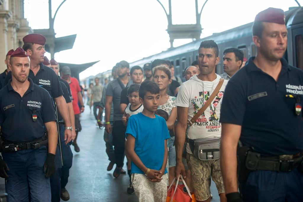 Budapest, 2015. szeptember 2. Illegális bevándorlókat egy Gyõrbe tartó vonathoz kísérnek rendõrök a Keleti pályaudvaron 2015. szeptember 2-án. MTI Fotó: Kallos Bea