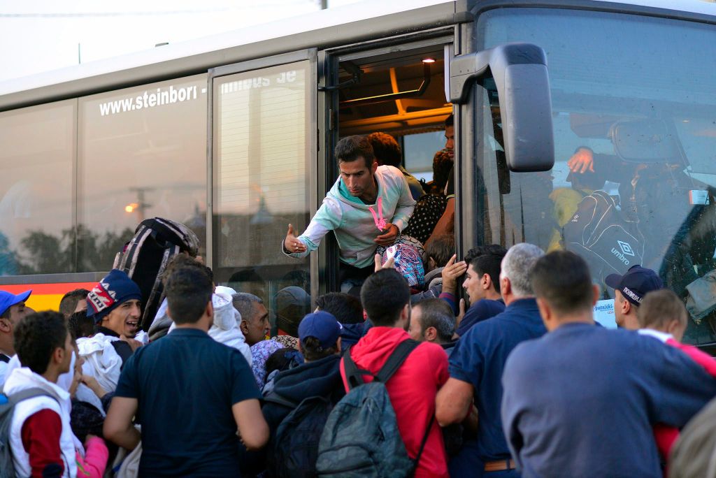 Magyarkanizsa, 2015. szeptember 14. Illegális bevándorlók buszra szállnak a szerbiai Magyarkanizsa vásárterén létrehozott ideiglenes pihenõhely elõtt 2015. szeptember 13-án. Több ezer migráns fordul meg itt naponta, többsége nem is megy be a pihenõhelyre, hanem busszal, taxival vagy gyalog indul tovább Magyarország felé. MTI Fotó: Molnár Edvárd