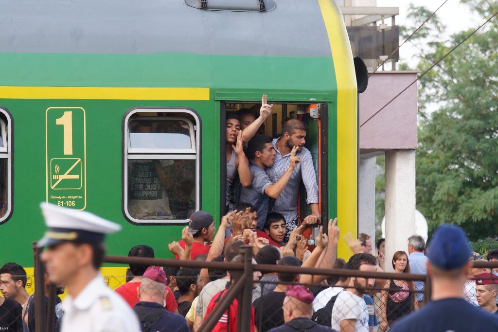 Bicske, 2015. szeptember 3. Rendõrök az illegális bevándorlókkal a budapesti Keleti pályaudvarról Sopronba közlekedõ, Bicskén megállított vonat mellett 2015. szeptember 3-án. A migránsok fõként az állomáson veszteglõ vonaton vannak. Körülbelül 30, többségében nõ és gyermek önként elhagyta az állomáson veszteglõ vonatot, õket busszal egy befogadóhelyre viszik. MTI Fotó: Balogh Zoltán