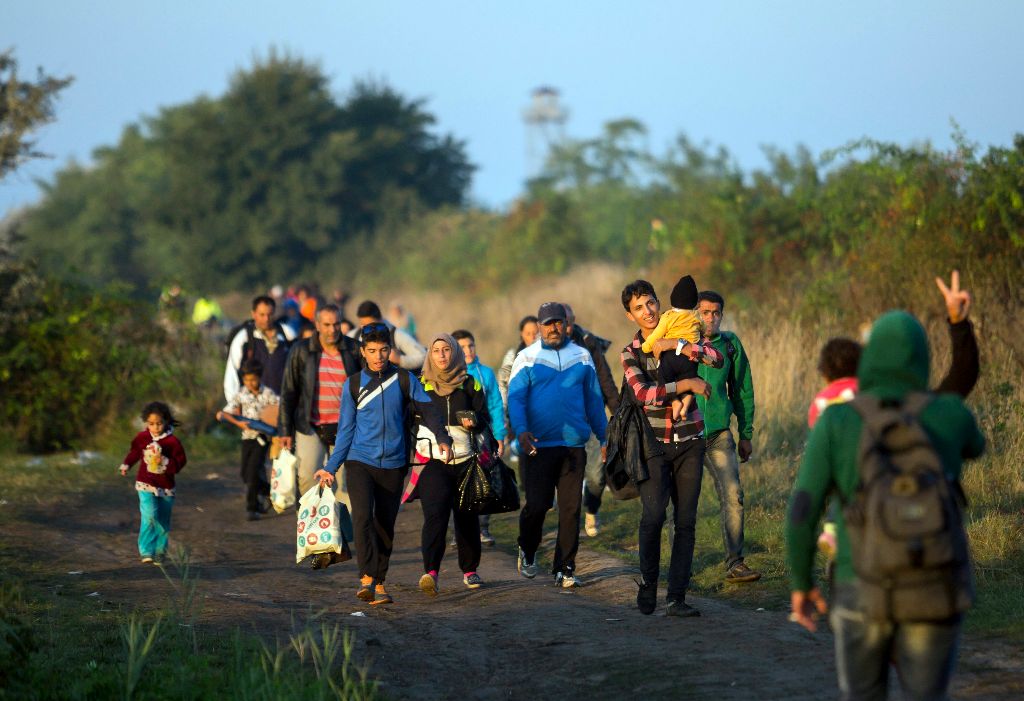 Röszke, 2015. szeptember 14. Illegális bevándorlók mennek a gyûjtõpont felé a magyar-szerb határon, a Horgos-Szeged vasútvonal mentén, Röszke közelében 2015. szeptember 14-én. MTI Fotó: Mohai Balázs