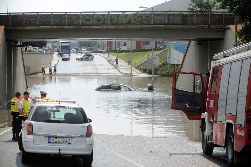Vecsés, 2016. július 23. Tûzoltók mentenek egy vízben elmerül személygépkocsit felhõszakadás után egy vecsési aluljárónál 2016. július 23-án. MTI Fotó: Mihádák Zoltán