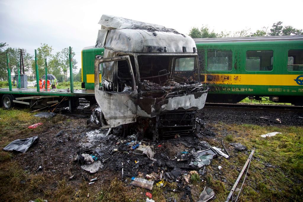 Barcs, 2016. július 25. Összeroncsolódott, kiégett kamion egy személyvonat mellett egy barcsi vasúti átjárónál 2016. július 25-én, miután a két jármû összeütközött. A kamion az ütközés következtében kigyulladt, vezetõje a helyszínen meghalt. A Sopron és Pécs között közlekedõ szerelvény mozdonyvezetõje és egy utasa könnyû sérülést szenvedett. MTI Fotó: Varga György