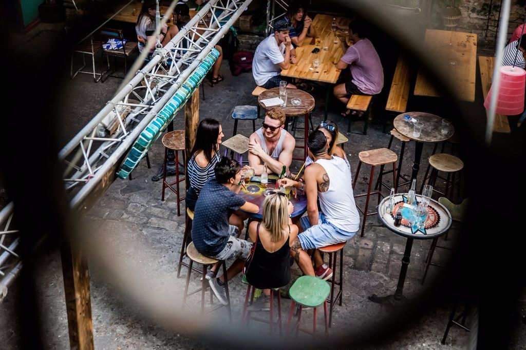 Budapest, 2016. augusztus 15. Az ausztrál Tess Gouldsmith (j), Laura Dunett (b) és Brittany Henderson (k, háttal), valamint az olasz Giuseppe Gesso (j2) és Domenico Arganese (b2), illetve a brit Robert Plumtree (k, szemben)  beszélget a Szimpla romkocsmában Budapesten 2016. augusztus 14-én. A fiatalok idén fejezték be egyetemi tanulmányaikat és a nyarat európai utazással töltik. A fesztivál zenei programján kívül kíváncsiak Budapest látnivalóira és a magyar ételkülönlegességekre is. MTI Fotó: Balogh Zoltán